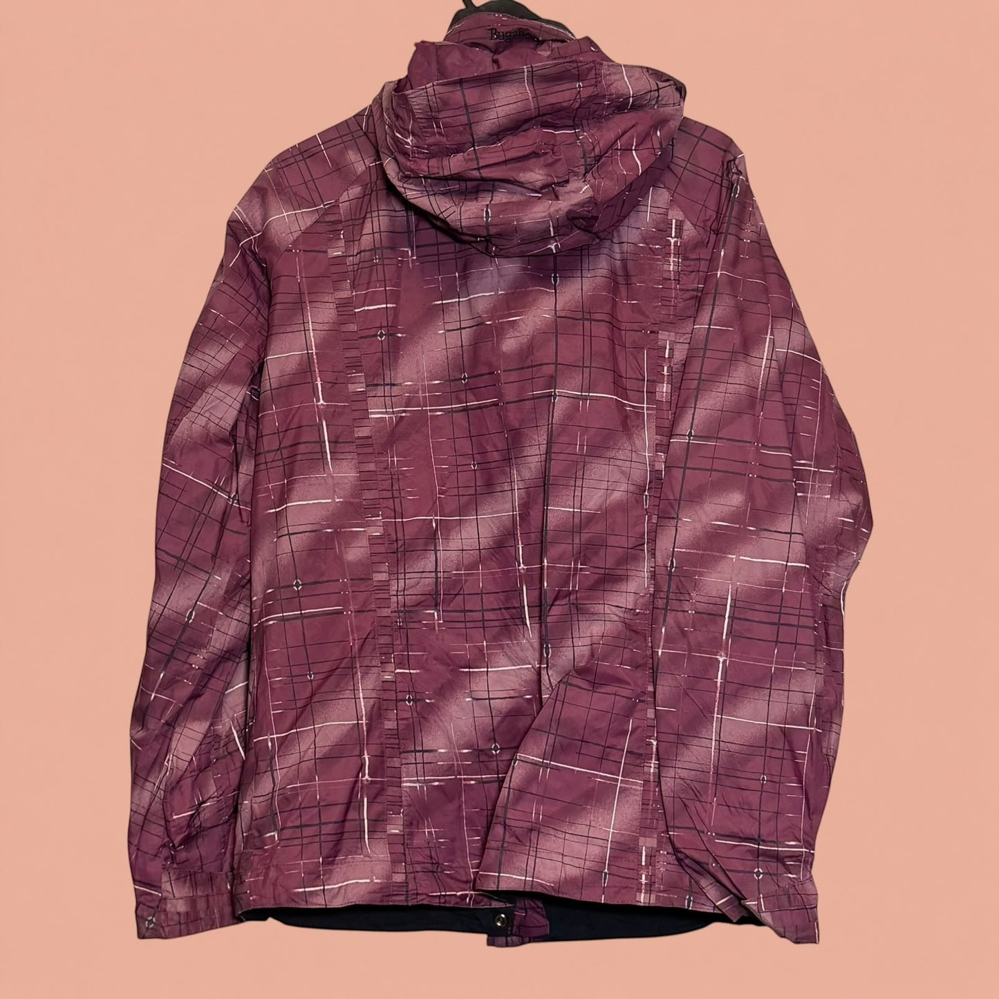 Chaqueta impermeable Tuclosetrenovado.cl de color morado con estampado de cuadros y capucha, vista trasera.