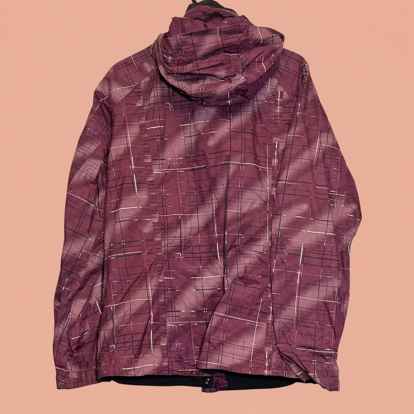Chaqueta impermeable Tuclosetrenovado.cl de color morado con estampado de cuadros y capucha, vista trasera.