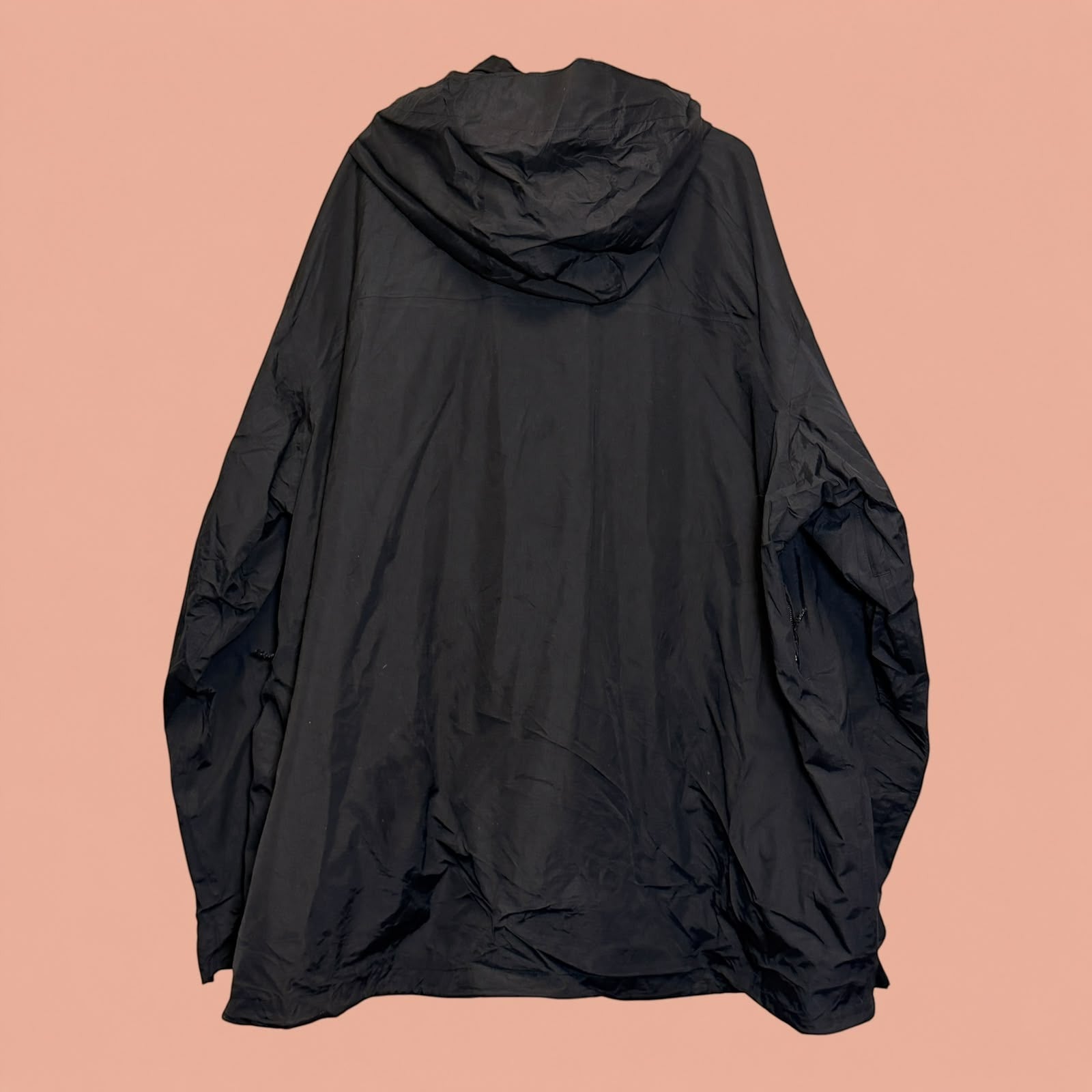Chaqueta impermeable negra con capucha de Tuclosetrenovado.cl, estilo técnico para hombre, vista trasera.