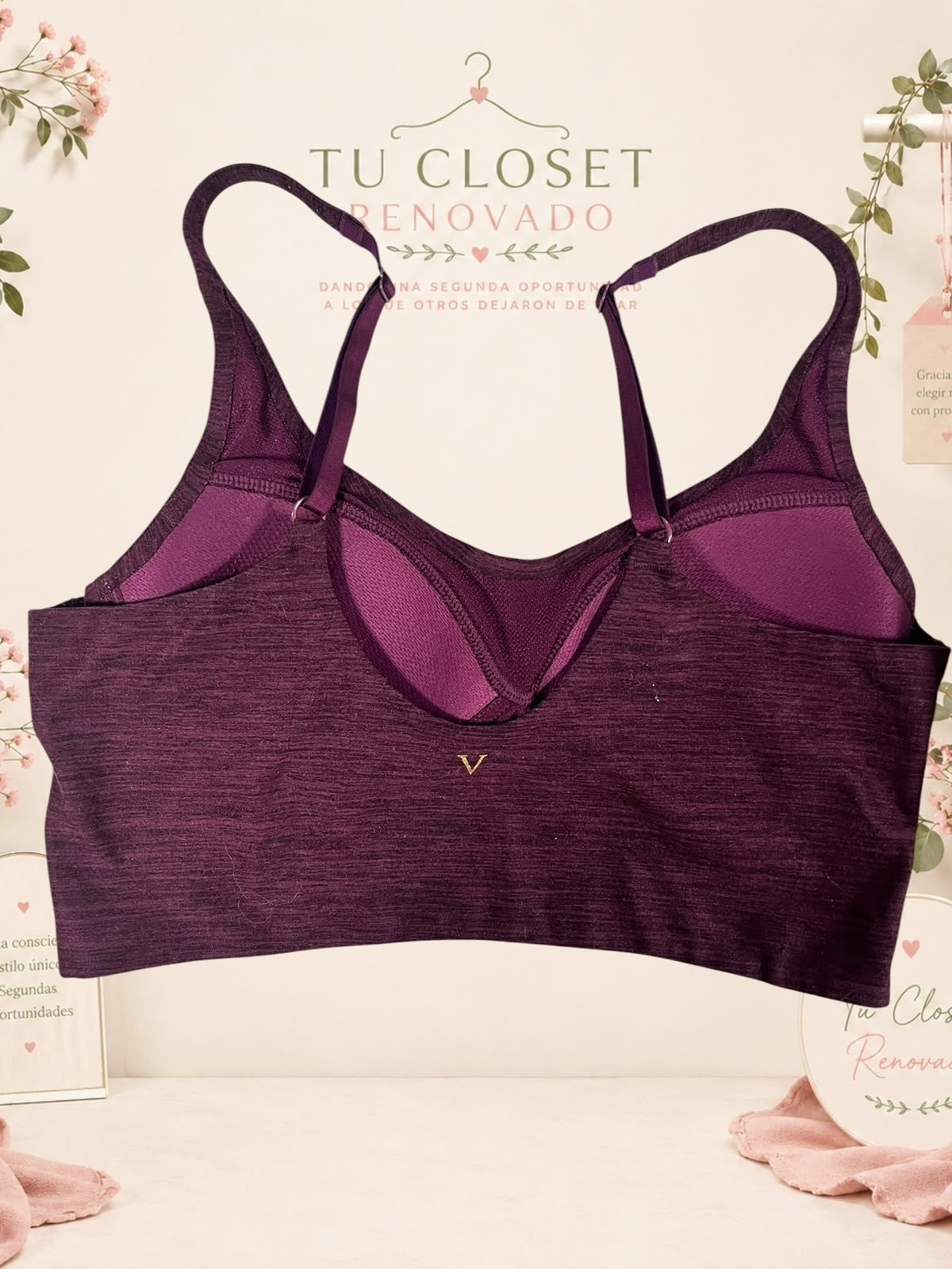 Sujetador deportivo morado de Tuclosetrenovado.cl con espalda cruzada y detalle de logo dorado