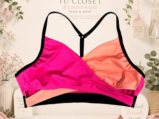 Top deportivo Tuclosetrenovado.cl de estilo cruzado en colores fucsia y naranja con tirantes negros ajustables