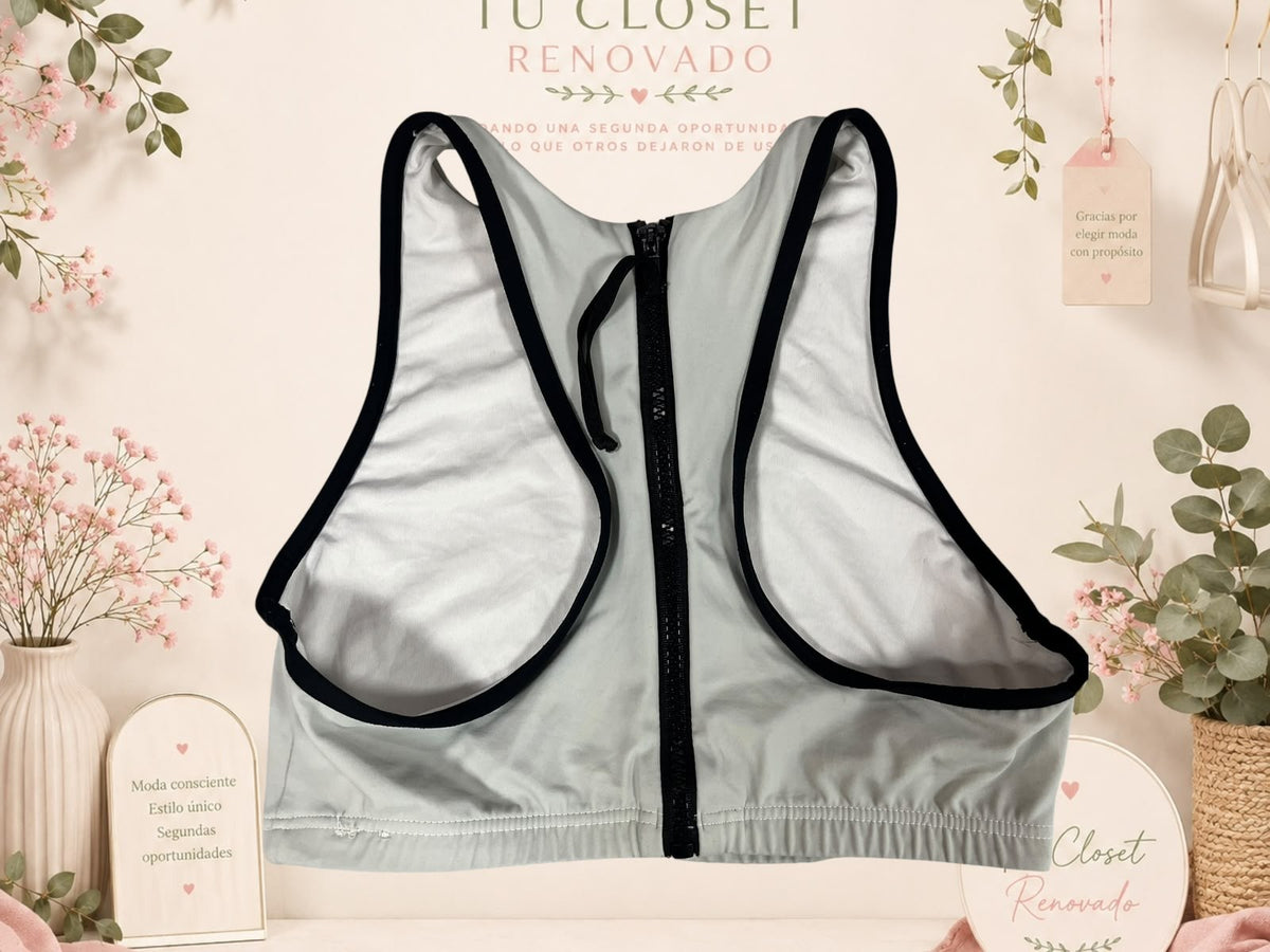 Top deportivo Tuclosetrenovado.cl gris con cierre frontal y bordes negros, ideal para entrenamiento