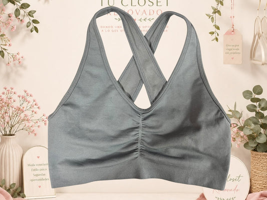 Top deportivo gris de Tuclosetrenovado.cl con diseño de espalda cruzada y detalle fruncido en el pecho