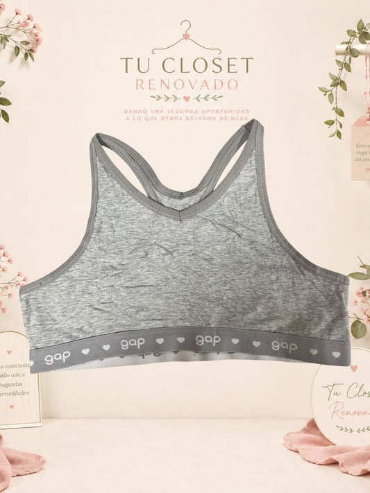 Top deportivo gris de algodón marca Tuclosetrenovado.cl con espalda cruzada y banda elástica con logo Gap