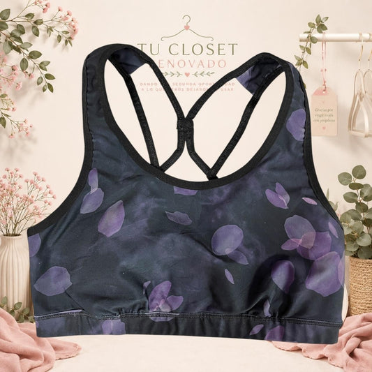 Top deportivo Tuclosetrenovado.cl negro con estampado de pétalos morados y tirantes cruzados en la espalda