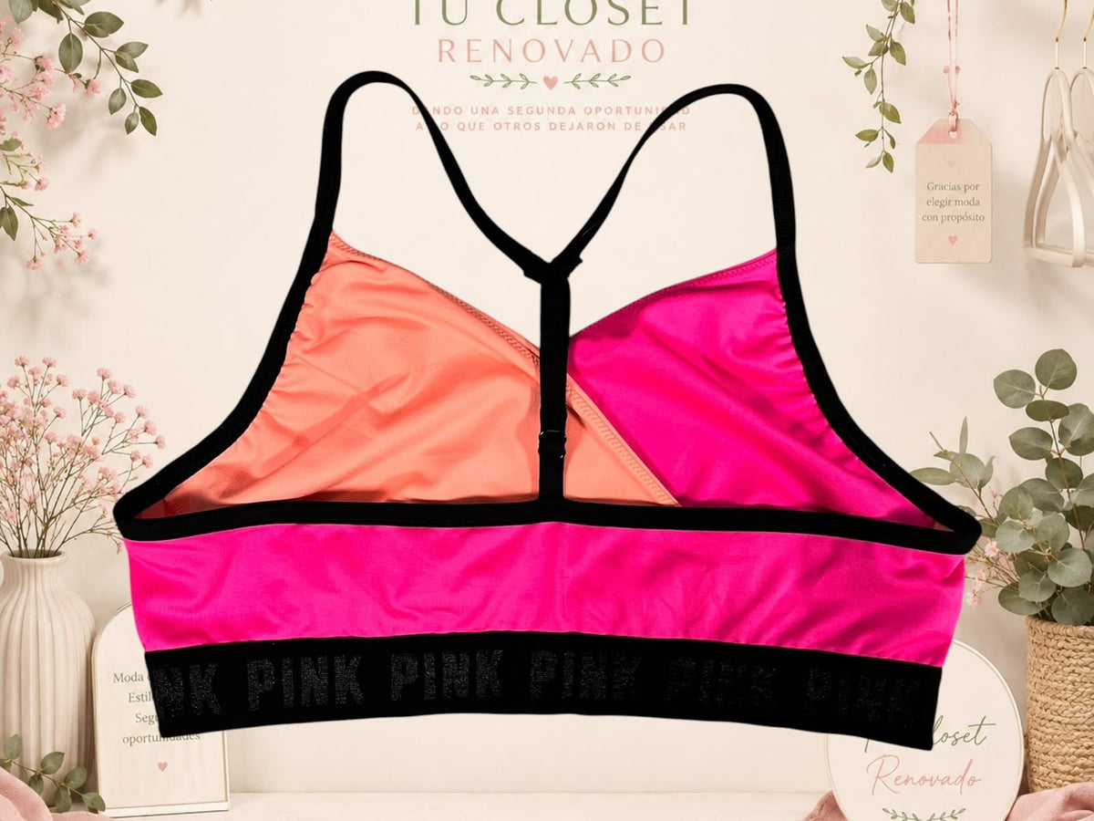 Top deportivo Tuclosetrenovado.cl de estilo racerback en bloques de color rosa y naranja con banda elástica negra.