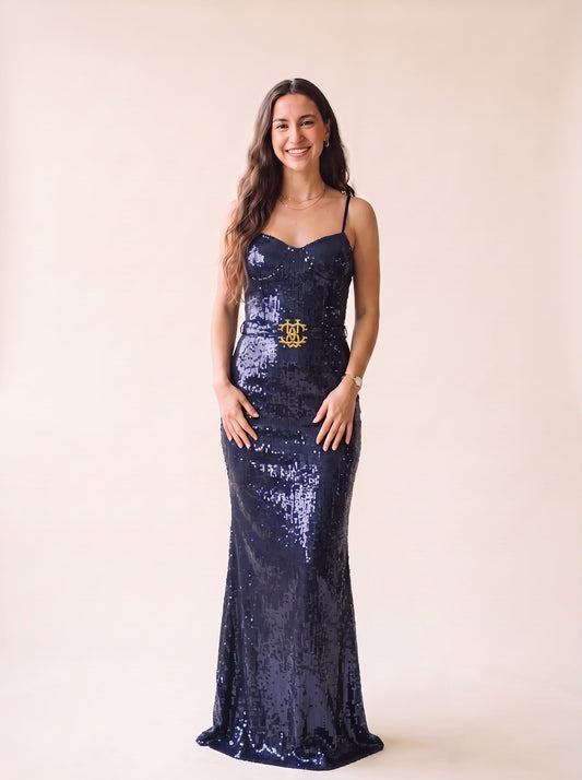 Mujer sonriente vistiendo un vestido largo de fiesta azul marino con lentejuelas y cinturón dorado de Tuclosetrenovado.cl