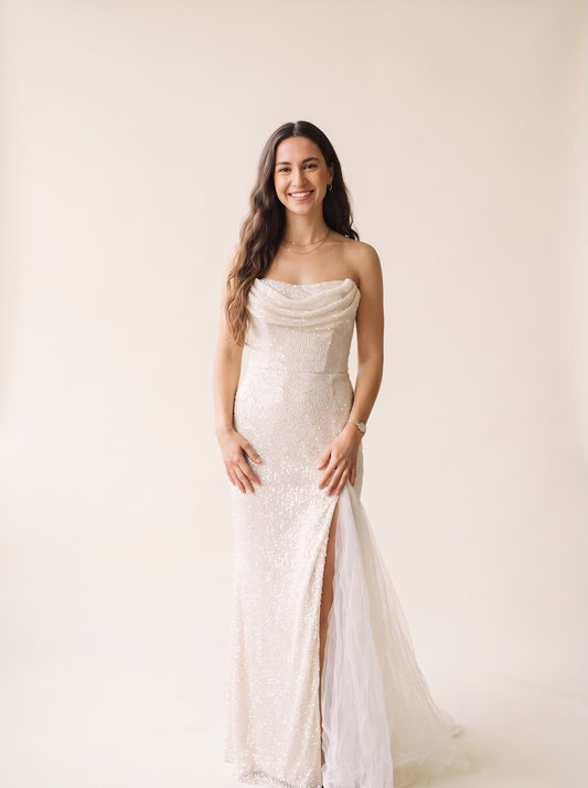 Mujer sonriente vistiendo un vestido largo de lentejuelas blanco con escote drapeado de Tuclosetrenovado.cl